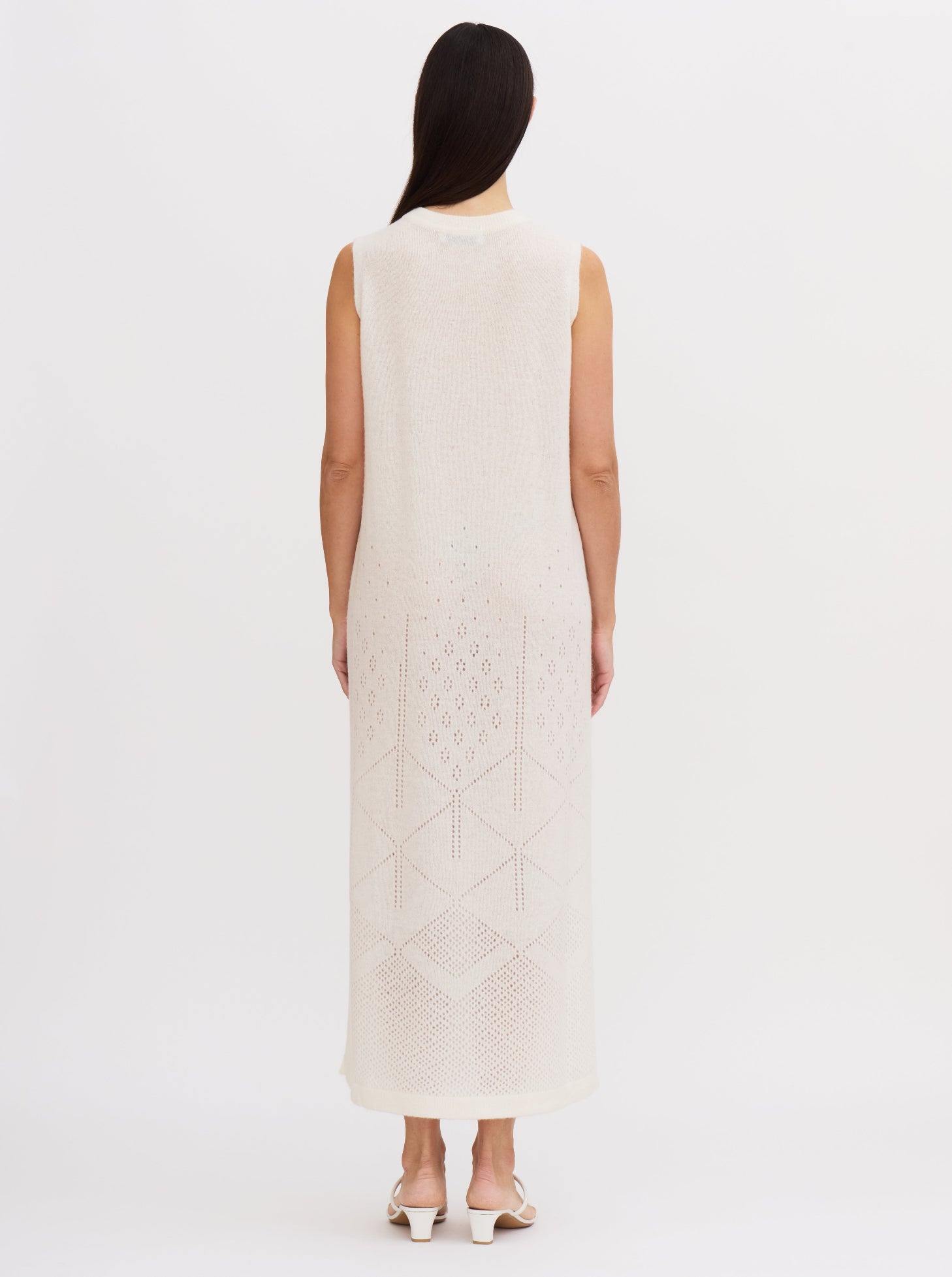 Back view of white sleeveless cashmere maxi dress with ajur knit design and geometric patterns at the hem.