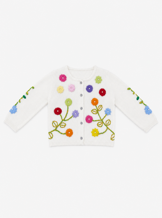 A white knit cardigan sweater with colorful embroidered flowers and green stems, featuring a snap-button front and long sleeves, shown against a plain white background.