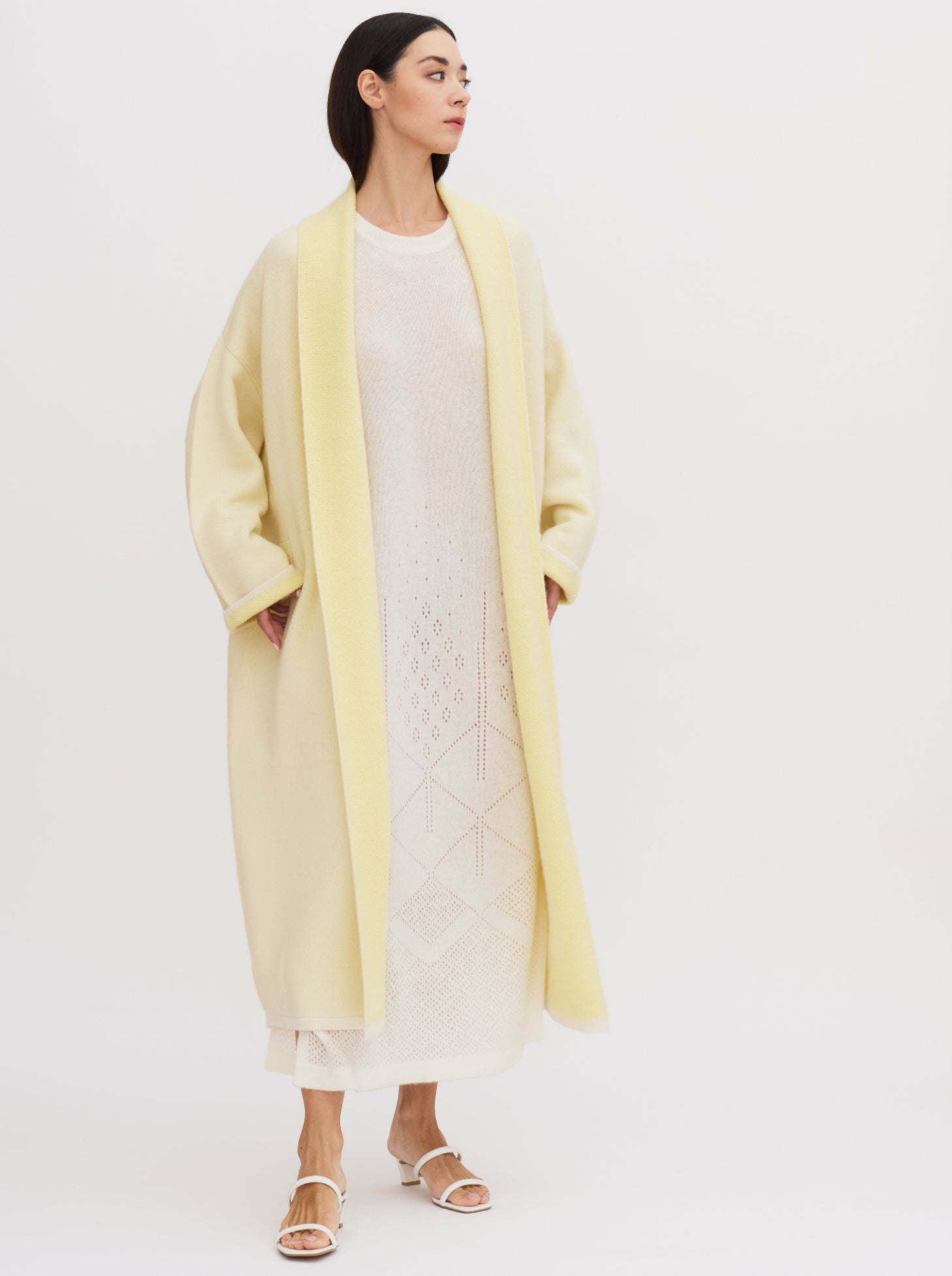 Long yellow balloon-shaped cashmere coat with a two-tone design and relaxed fit, featuring a shawl collar and wide sleeves.