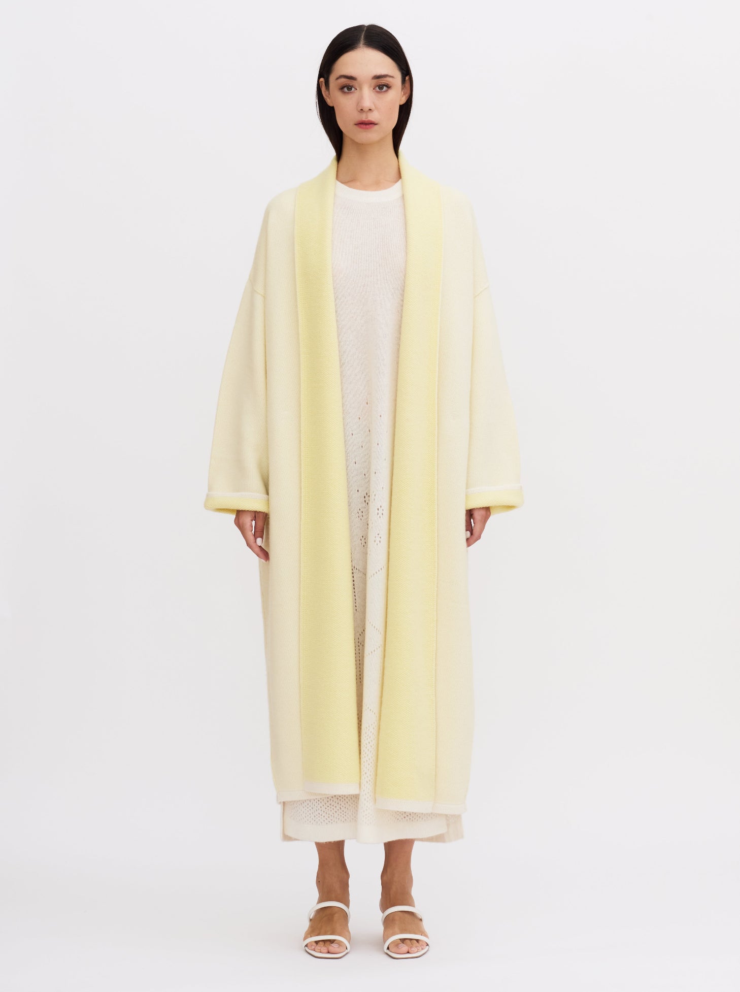 Long yellow balloon-shaped cashmere coat with a two-tone design and relaxed fit, featuring a shawl collar and wide sleeves.