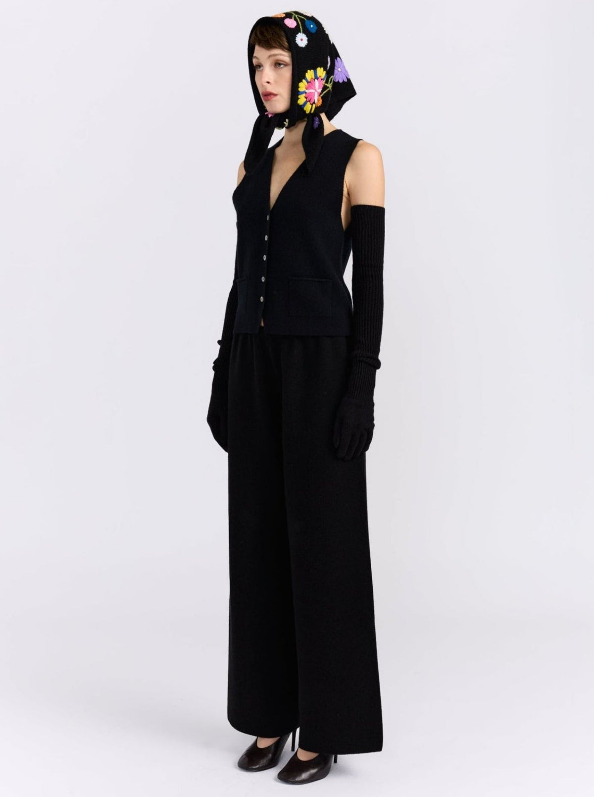 Model wearing the MANDKHAI black embroidered triangle cashmere scarf styled as a headscarf.
