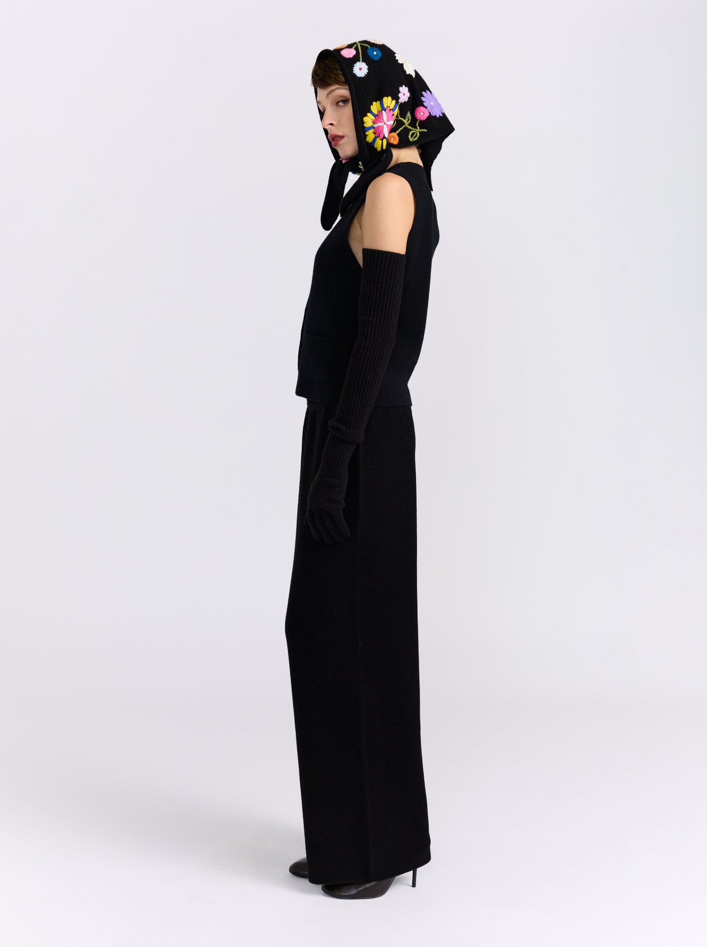 Model wearing the MANDKHAI black embroidered triangle cashmere scarf styled as a headscarf.