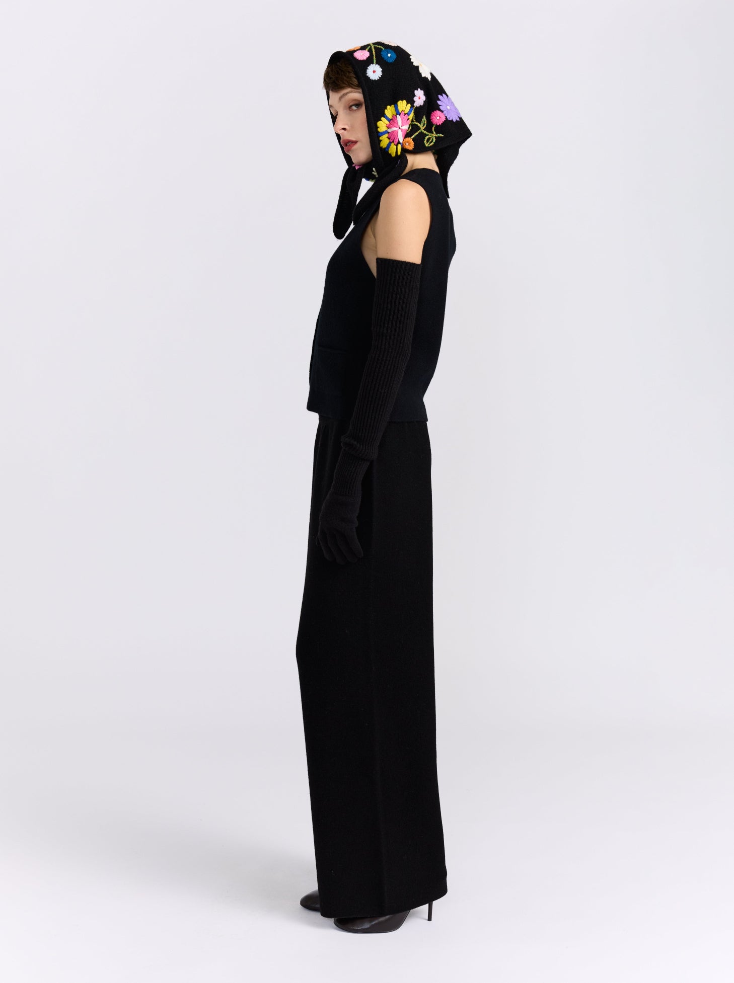 Model wearing the MANDKHAI black embroidered triangle cashmere scarf styled as a headscarf.