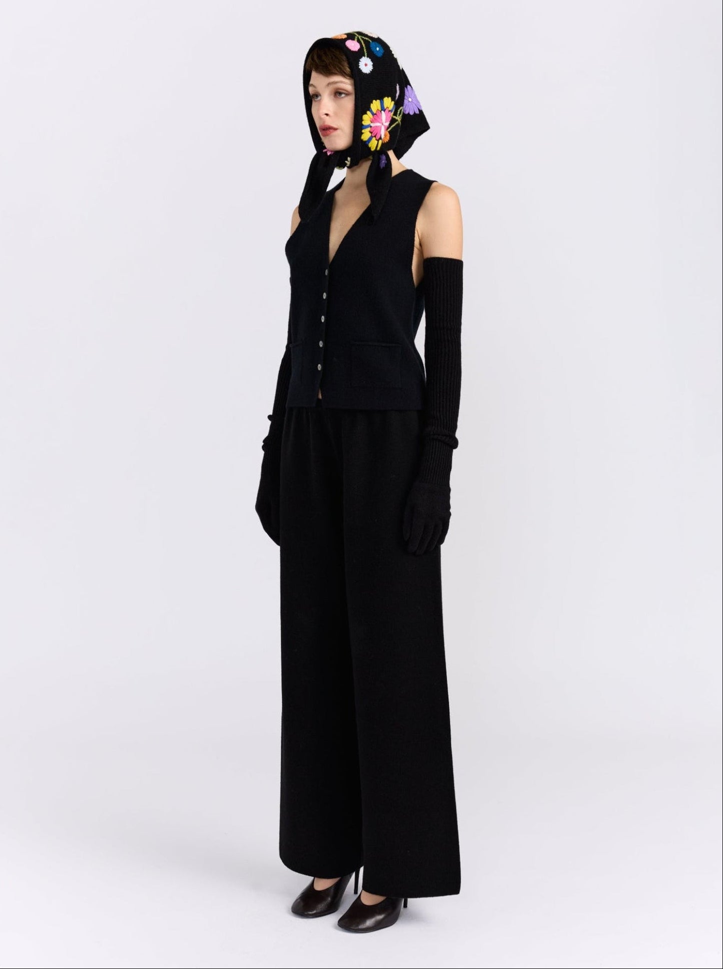Model wearing the MANDKHAI black embroidered triangle cashmere scarf styled as a headscarf.