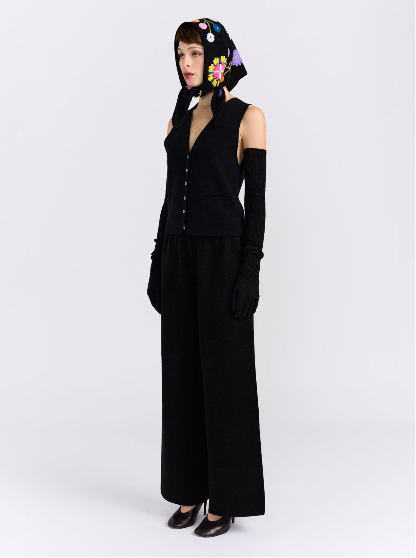 Model wearing the MANDKHAI black embroidered triangle cashmere scarf styled as a headscarf.