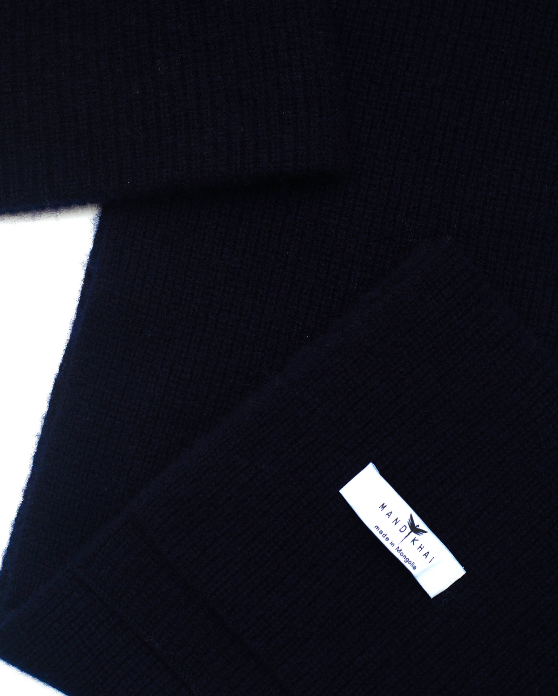 flat lay close up of dark navy cashmere ribbed knit scarf and hat set with mandkhai label detail 