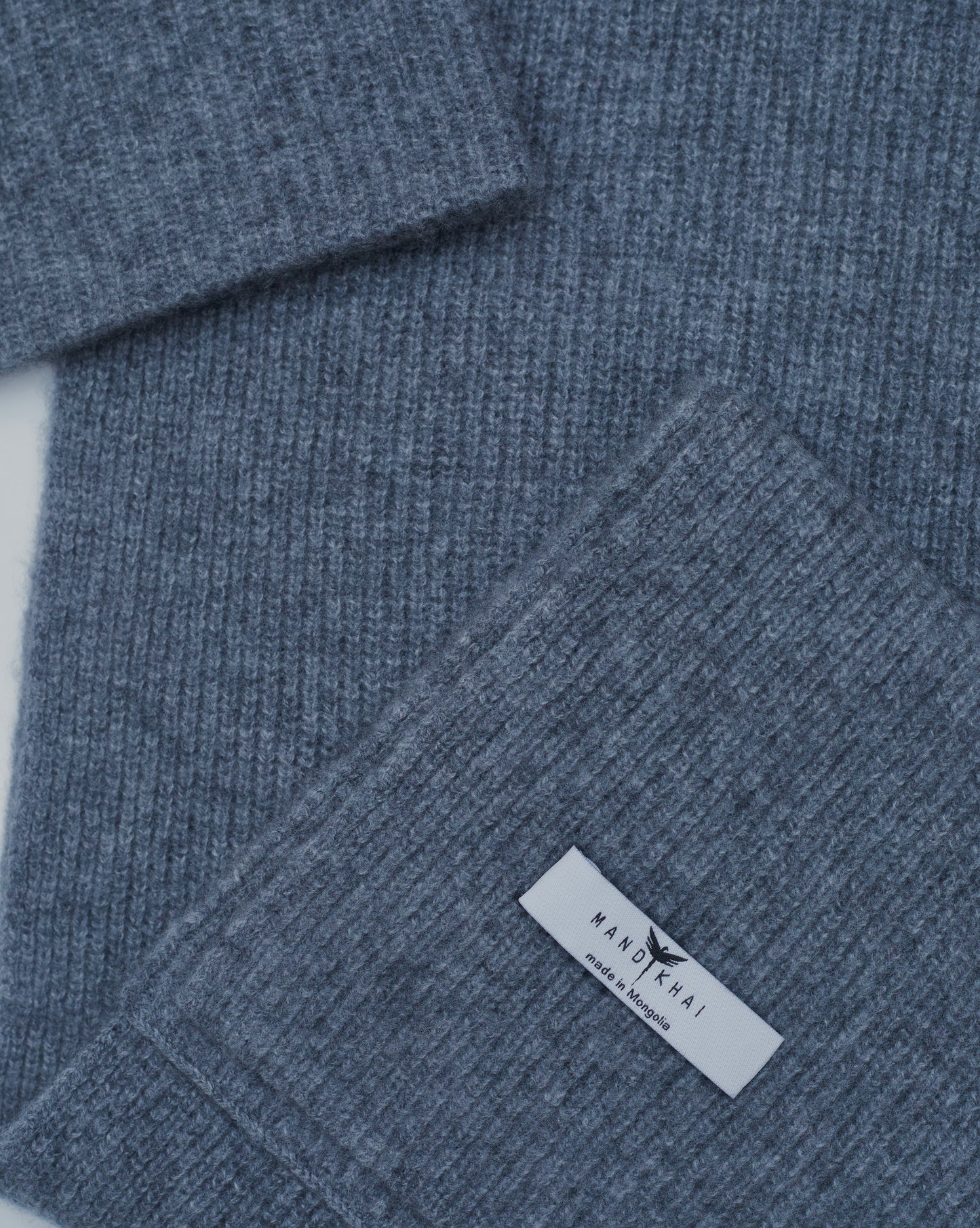 flat lay close up of grey cashmere ribbed knit scarf and hat set with mandkhai label detail 