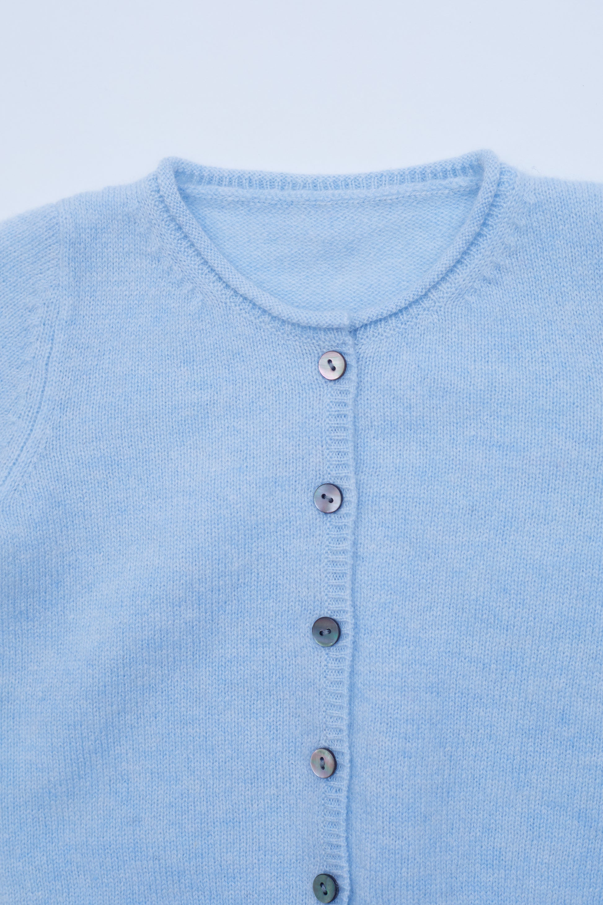 Close up button detail of the light blue baby cashmere cardigan 