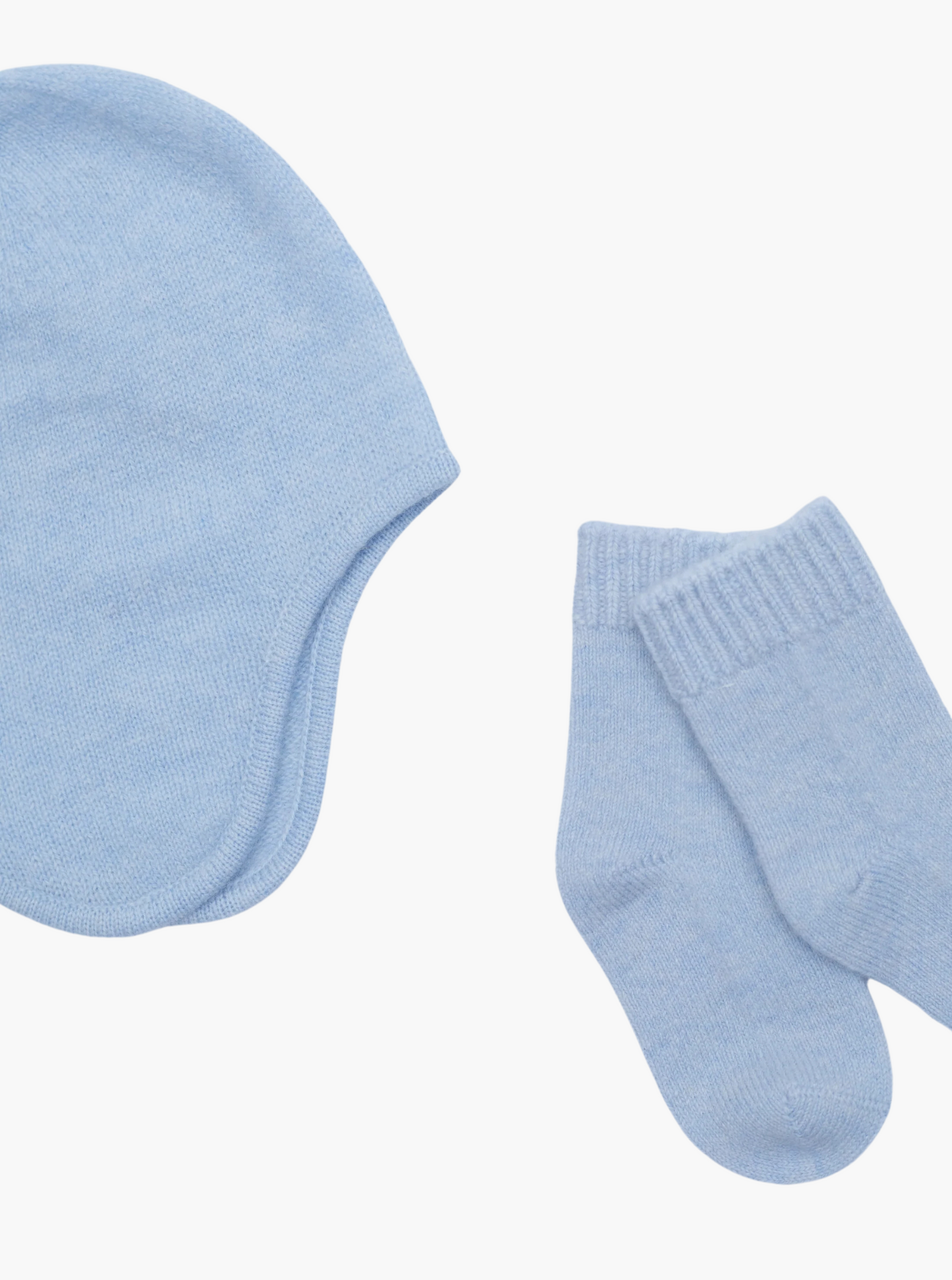 close up flat lay of the light blue cashmere baby hat and socks set 