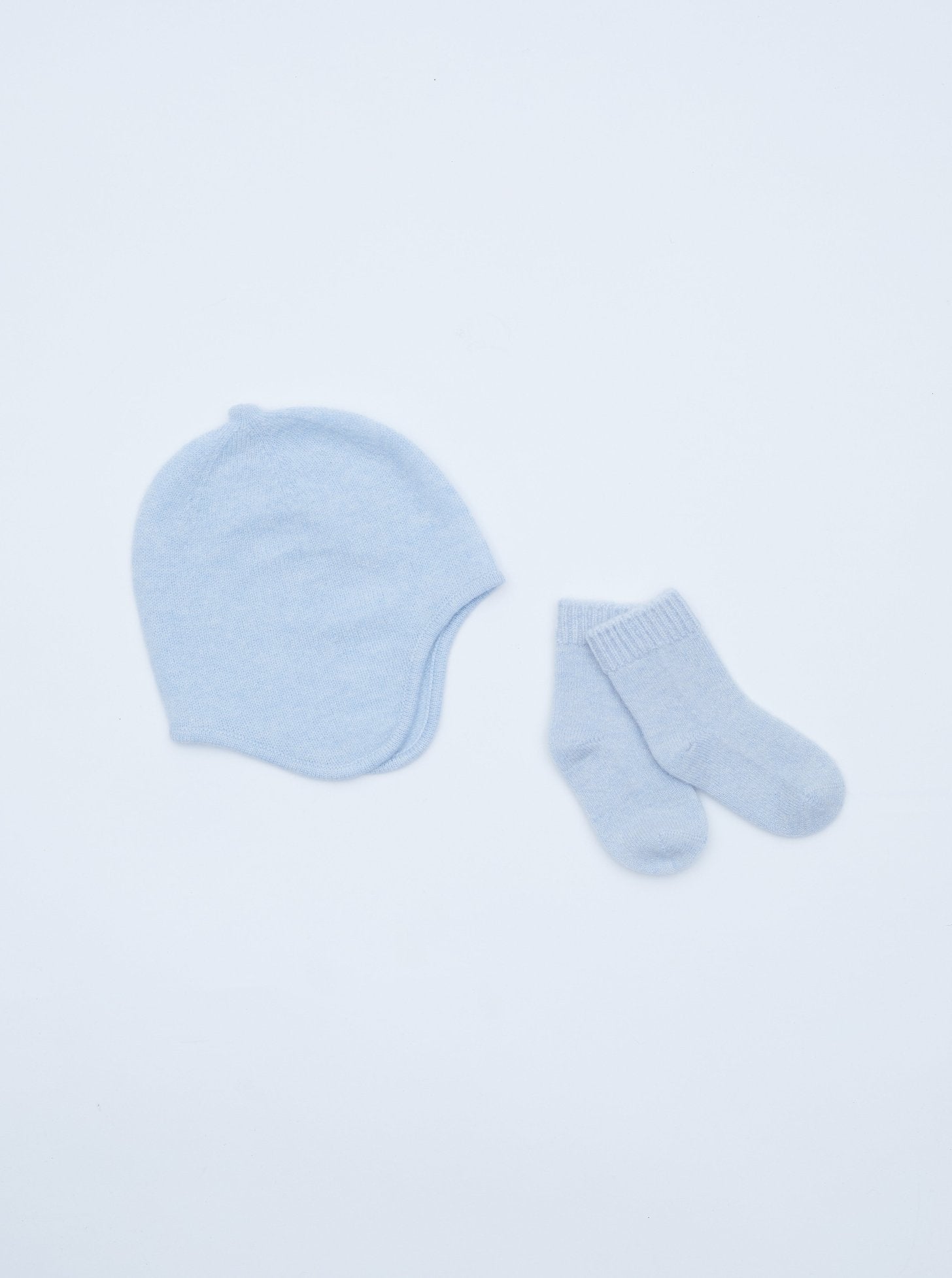 flat lay of the light blue cashmere baby hat and socks set