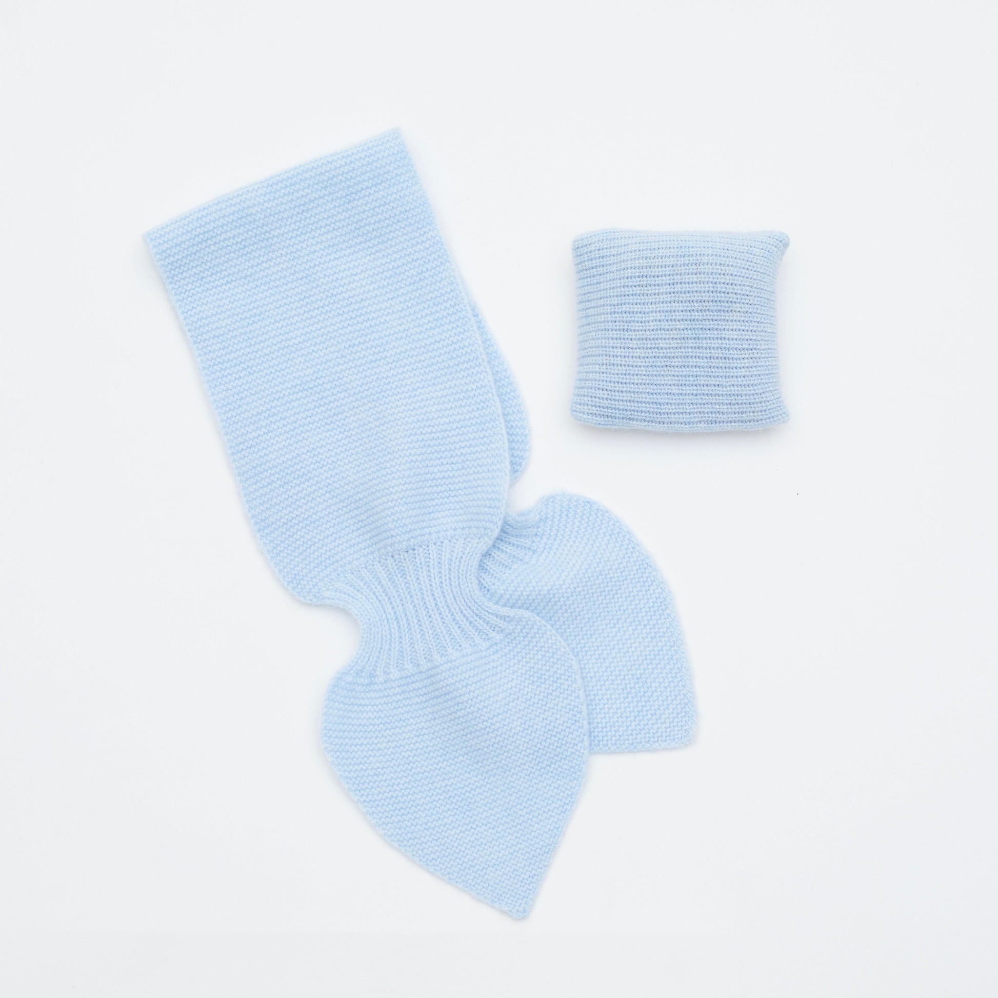 Flat lay of light blue cashmere neck scarf and light blue mini lavender cushion set 