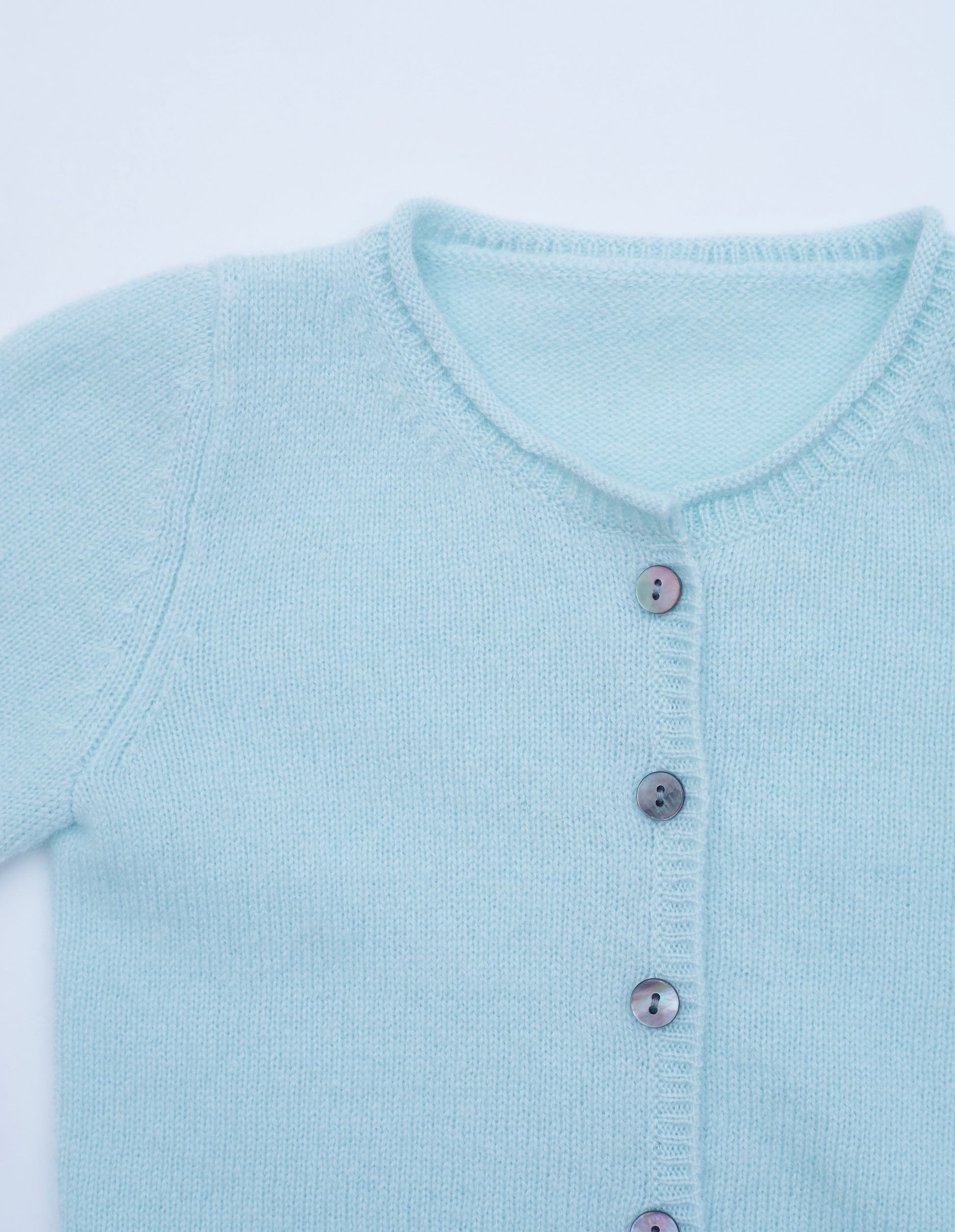 Close up button detail of the mint green baby cashmere cardigan 