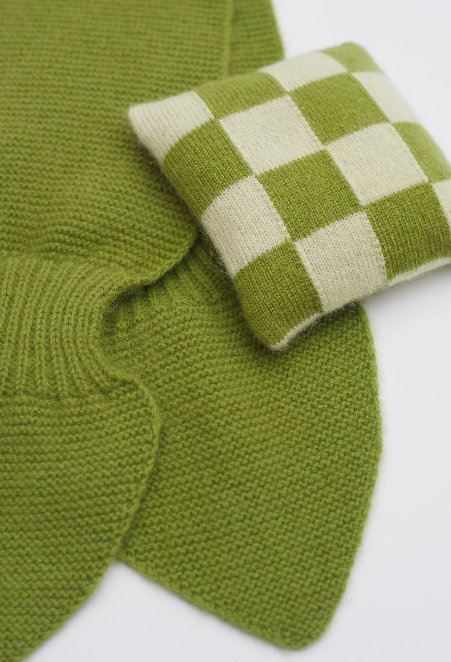 Close up flat lay of olive green cashmere neck scarf and olive green and light yellow checked mini lavender cushion set 