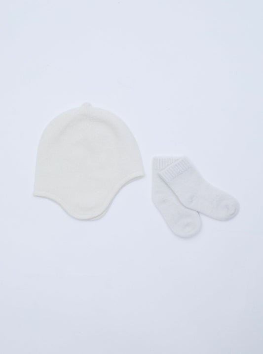 flat lay of the white cashmere baby hat and socks set 